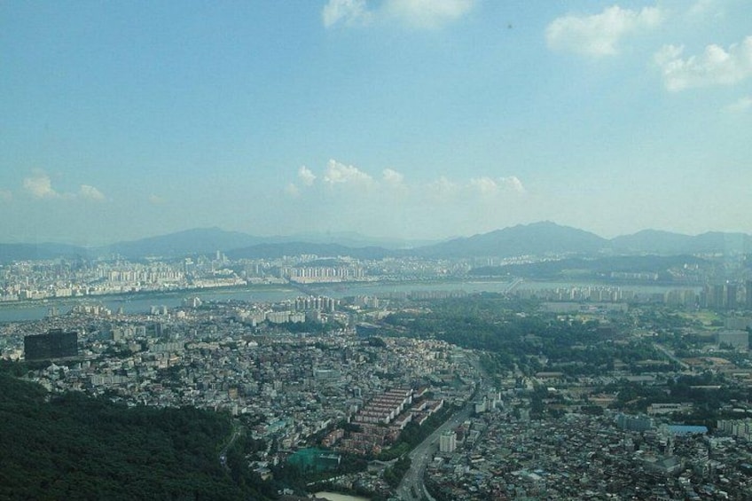 A cityscape with a river, mountains in the background, and a dense urban area. 2