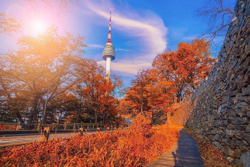 A tower, autumn foliage, and a stone wall. 4
