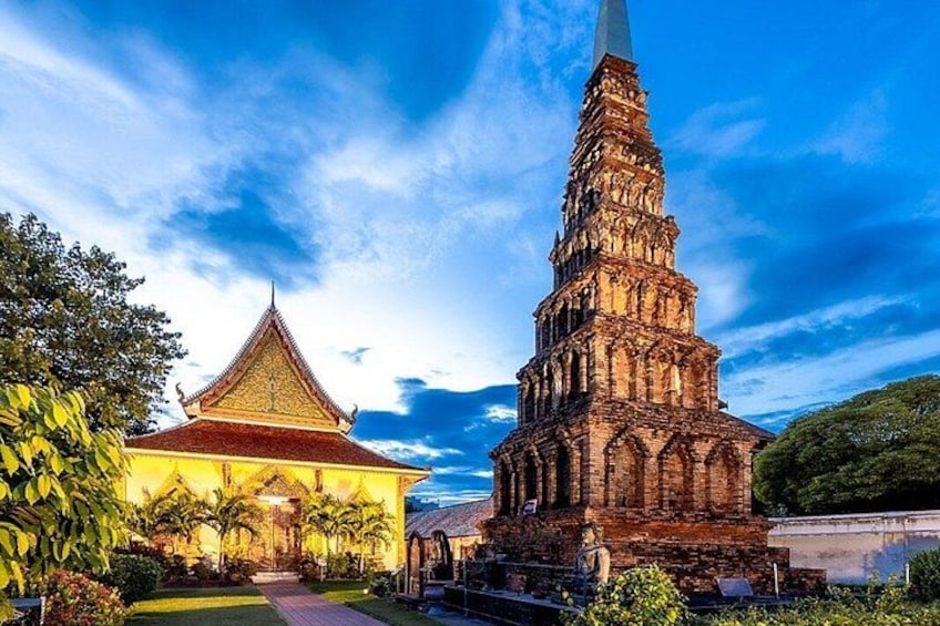 A temple with a tall spire and a traditional building with a pointed roof. 1
