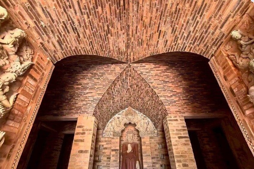 A brick archway with a statue at the center. 4