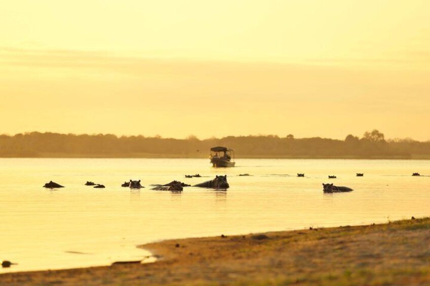A calm lake with several boats and a vehicle on the water. 4