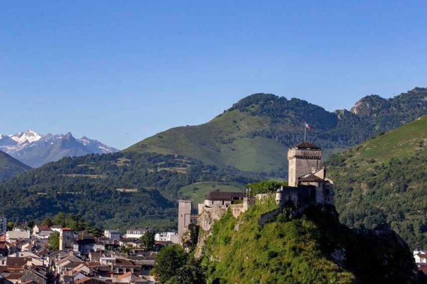 A mountainous town with a prominent tower and buildings on a hill. 2