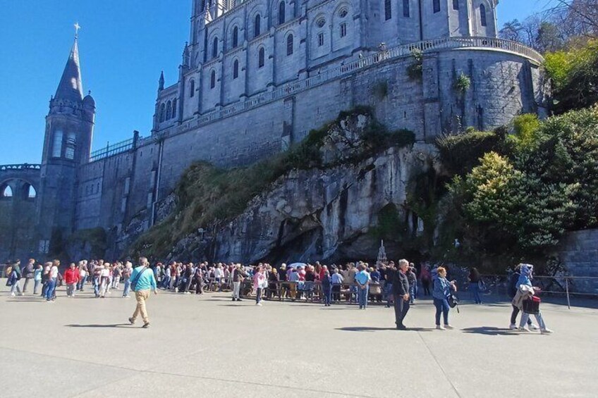 A large crowd in front of a historic stone building with a prominent tower. 4