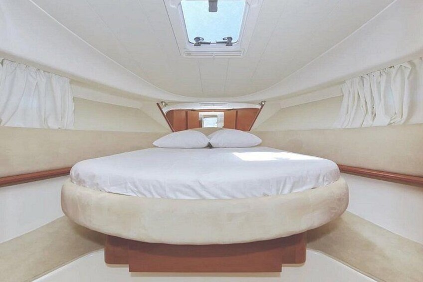 A bedroom with a bed, curtains, and a skylight. 4