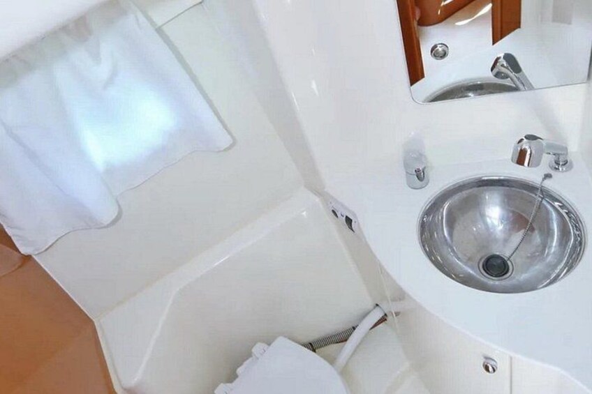 A bathroom with a white sink, a mirror, and a towel hanging on the wall. 5