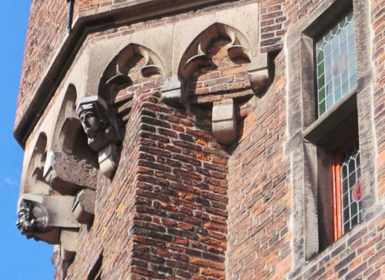 A brick building with arched windows and a statue on the corner. 5