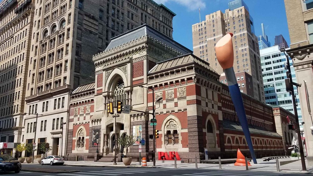 A historic building with ornate architecture, a traffic light, and a large sculpture. 1