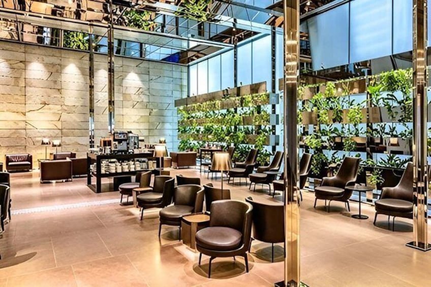 A modern indoor space with seating, plants, and a stone wall. 2