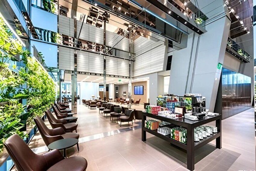 A modern indoor space with seating, a display of products, and a large window overlooking greenery. 4