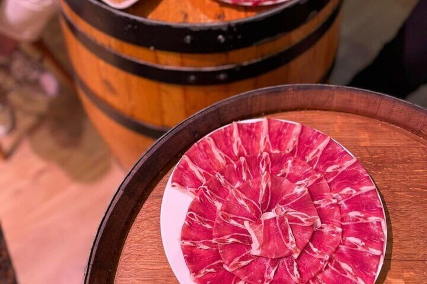 A wooden barrel and a plate with sliced meat. 2