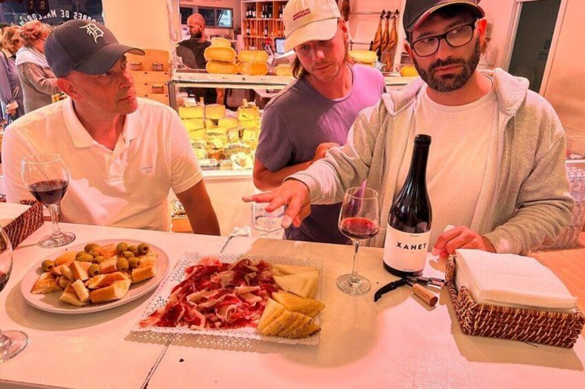 Three people at a table with food and wine. 4
