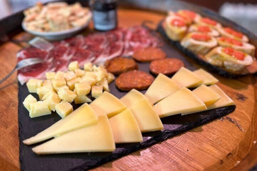 A charcuterie board with various cheeses, cured meats, and small pastries. 3