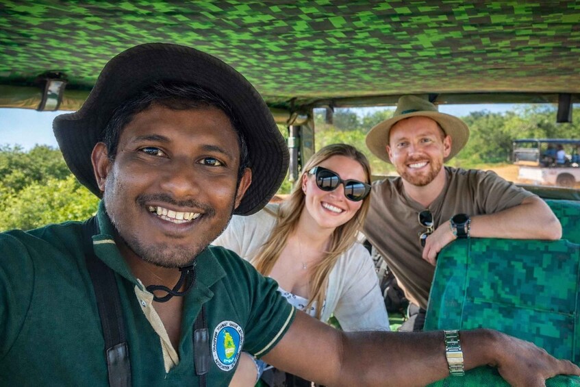 Three people in a safari vehicle with a green camouflage interior. 3