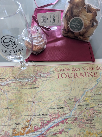 A map of Touraine, a wine glass, and a bag of biscuits. 4