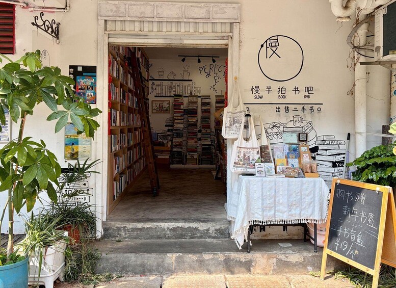 A bookstore with a sign reading 'SLOW BOOK BAR' and a chalkboard sign advertising books for sale. 4