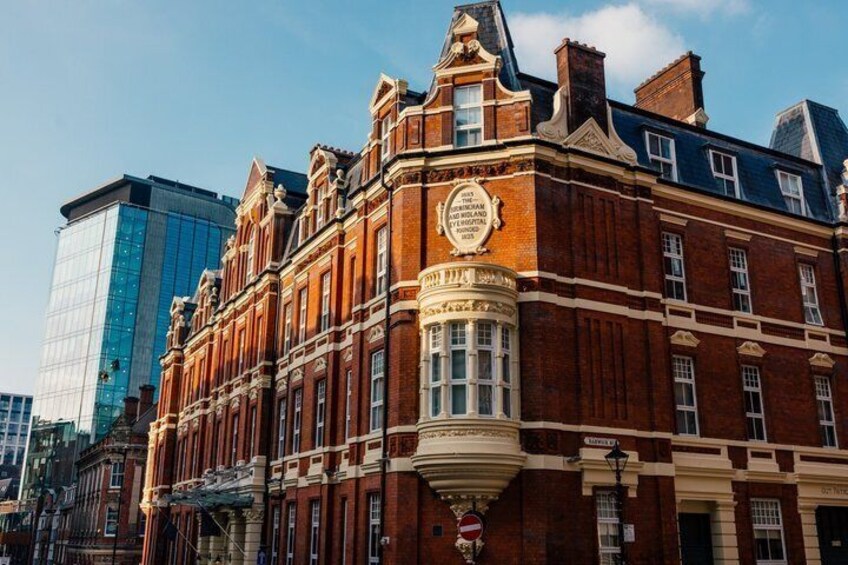 A historic red brick building with ornate detailing and a prominent clock tower. 2