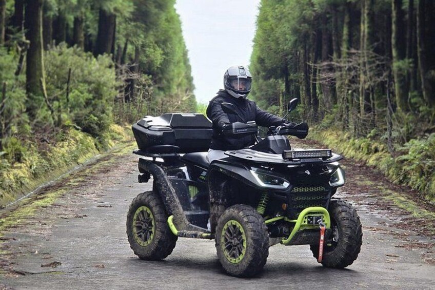 A person riding an all-terrain vehicle on a forest path. 2