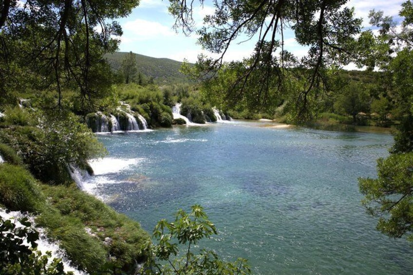 A river with waterfalls surrounded by lush greenery. 2