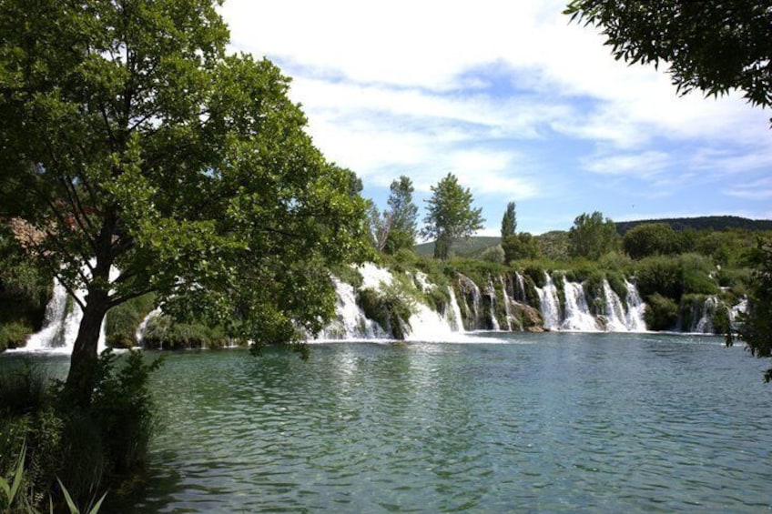 A waterfall cascading into a lake surrounded by trees. 3