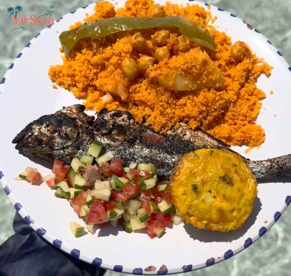 A plate with grilled fish, couscous, a green pepper, and a side of diced vegetables. 2