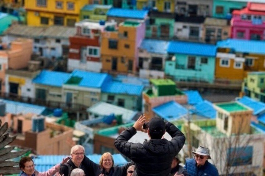 A group of people taking a photo of colorful buildings. 1
