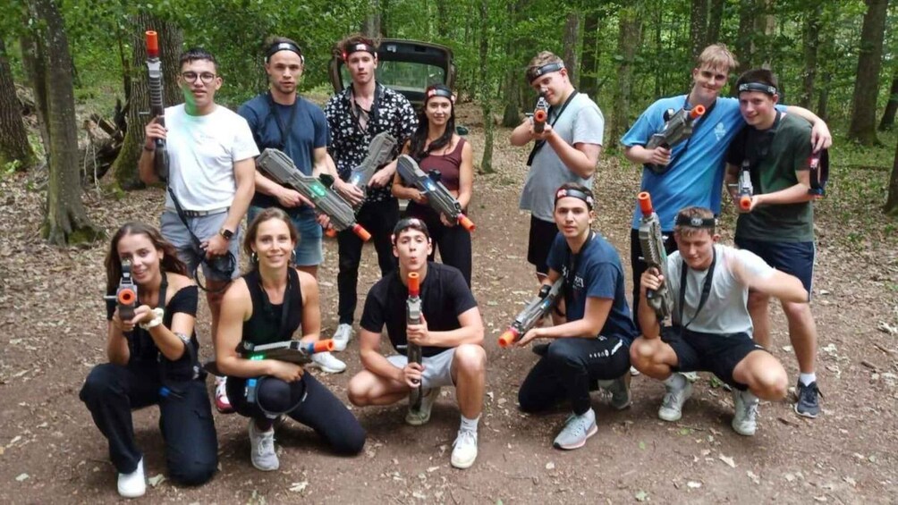 A group of people in a forest with paintball guns. 5