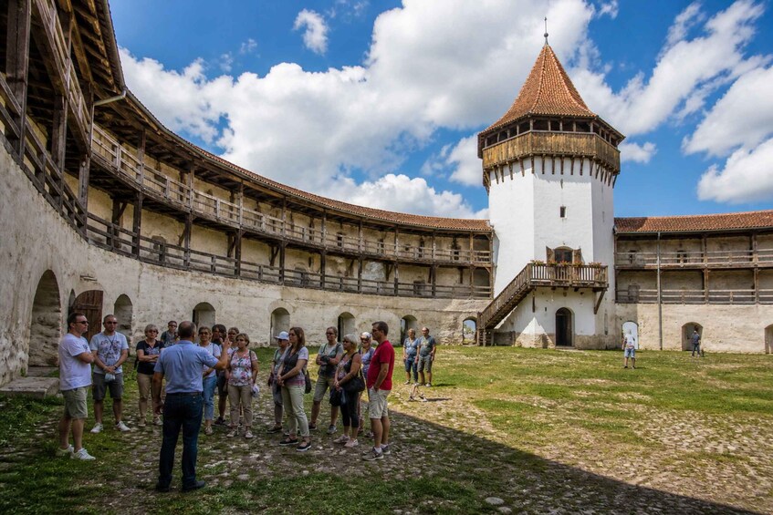 A historical building with a central tower and a courtyard. 3