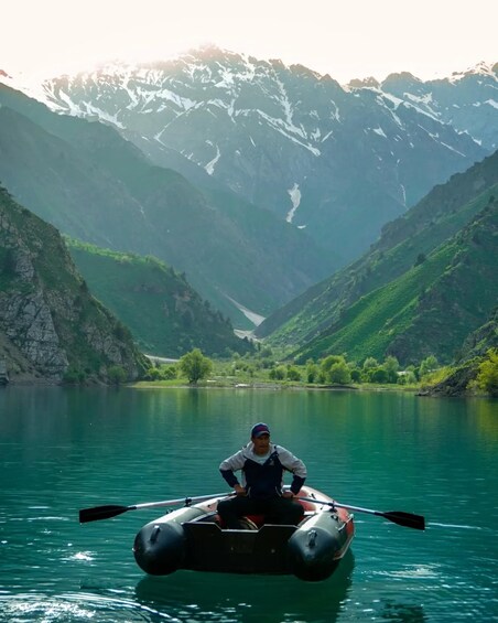 Une personne pratiquant le kayak sur une rivière paisible, entourée de montagnes. 4