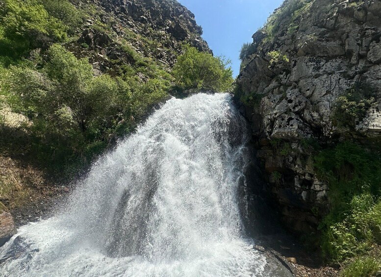 Une cascade se déversant le long d’une falaise rocheuse, entourée d’une végétation luxuriante. 1