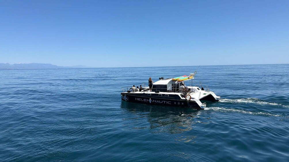 A boat named 'HELENNAUTIC' on the water with a clear sky. 3