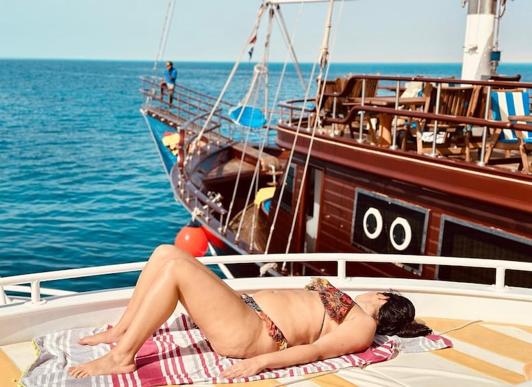 A person sunbathing on a boat with a view of the ocean. 4