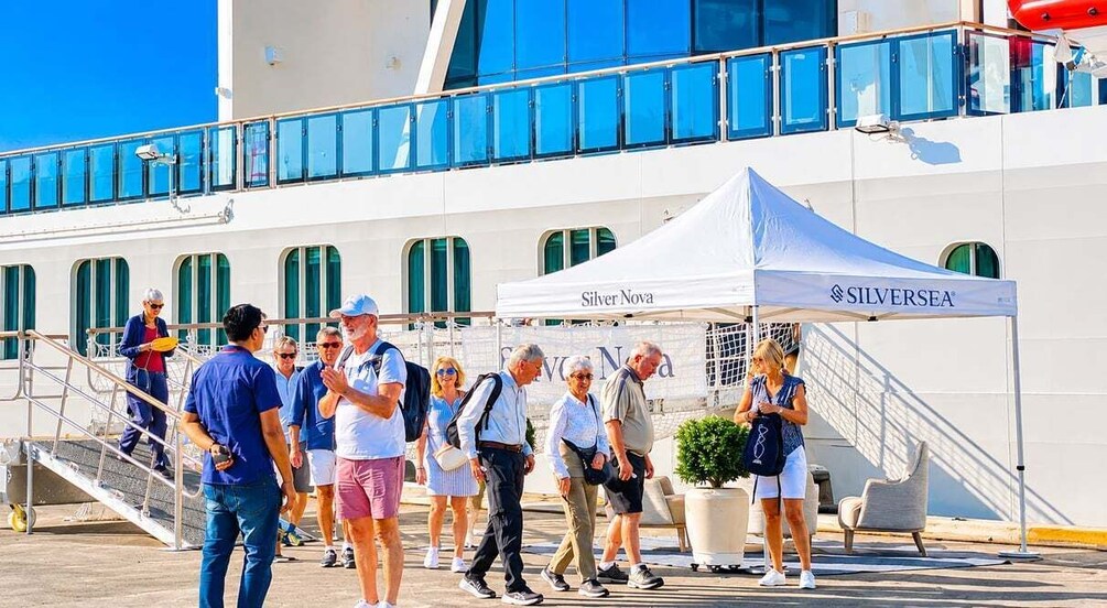 A group of people on a dock with a cruise ship in the background and a tent labeled 'SILVERSEA.' 3