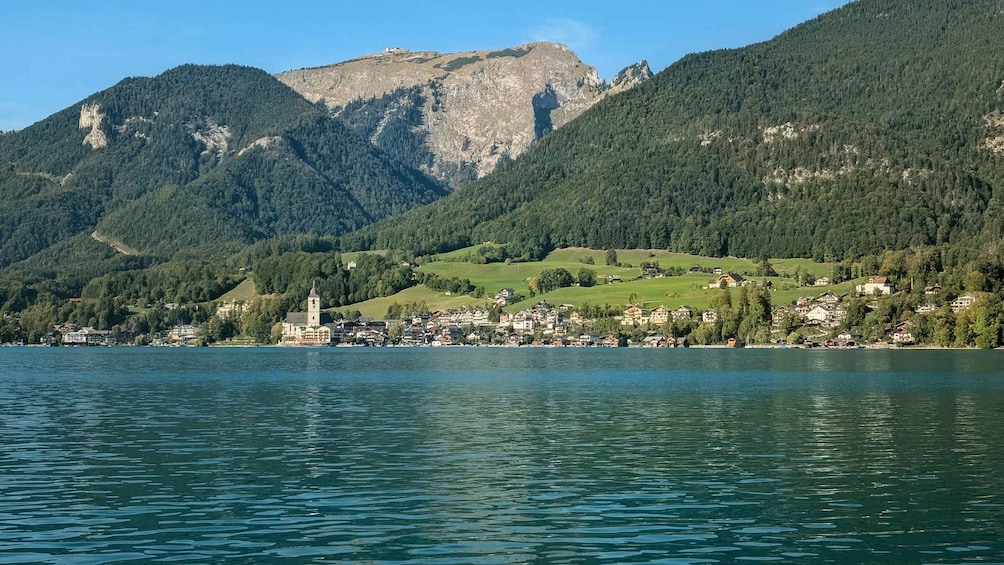 A lake with a town and mountains in the background. 3