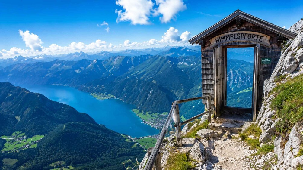 A wooden mountain hut named 'HIMMELSPORTE' with a scenic view of a lake and mountains. 5