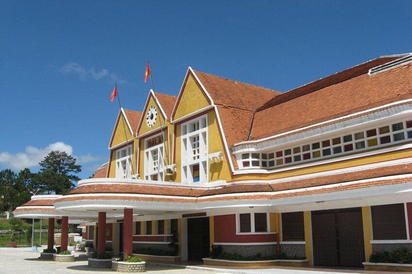A yellow building with a red roof, multiple windows, and flags. 3