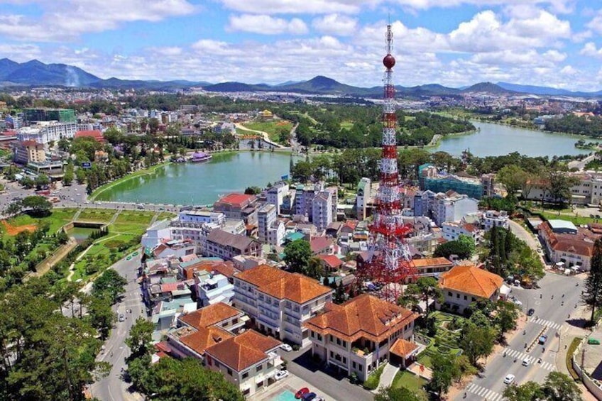 A cityscape with a prominent tower, a river, and surrounding greenery. 1