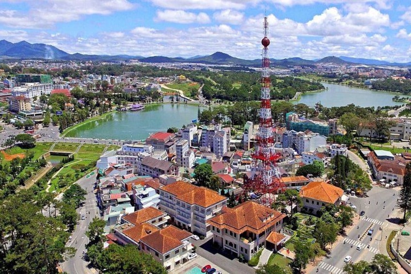 A cityscape with a prominent tower, a river, and surrounding greenery. 1