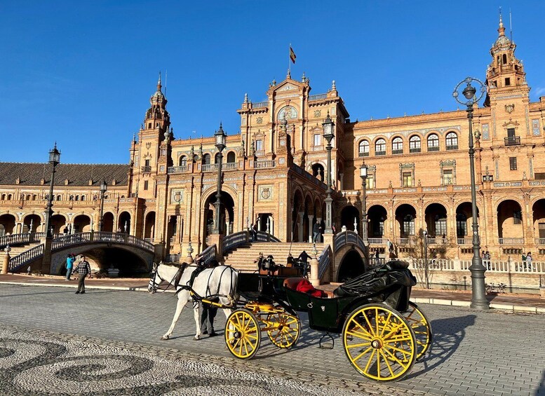 A historic building with arches and a horse-drawn carriage in front. 1