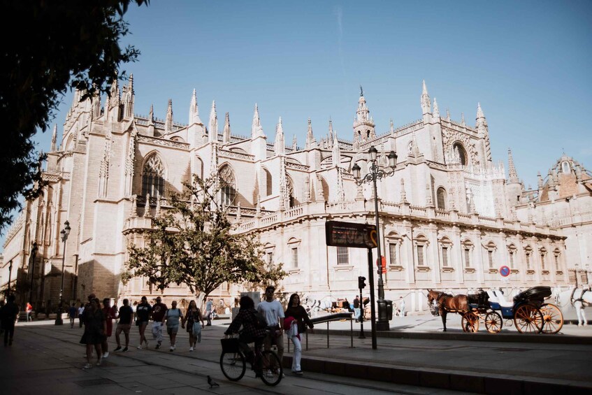A historic cathedral with intricate architecture, a horse-drawn carriage, and pedestrians on the street. 5