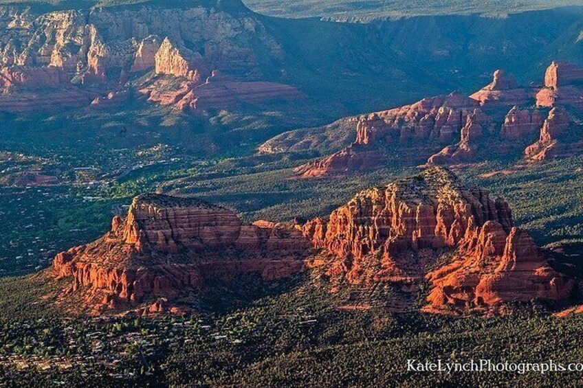 A canyon landscape with prominent red rock formations and sparse vegetation. 2