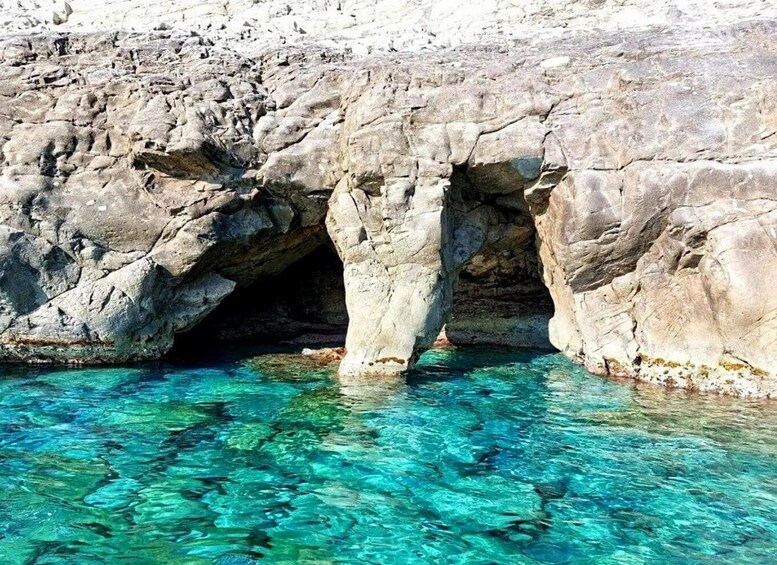 A rocky cave entrance with clear turquoise water. 1