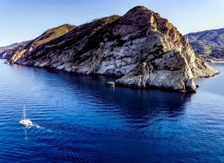 A rocky island surrounded by deep blue water. 4