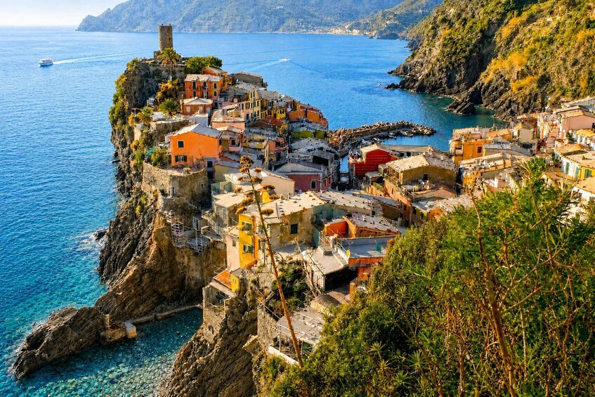 A coastal village with colorful buildings, a tower, and clear blue waters. 5