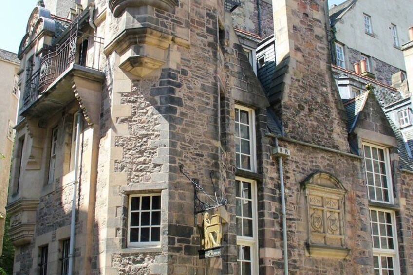 A historic stone building with arched windows and a balcony. 5