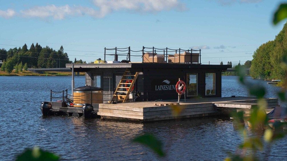 A floating dock with a lifebuoy and a ladder, surrounded by calm water and trees. 3