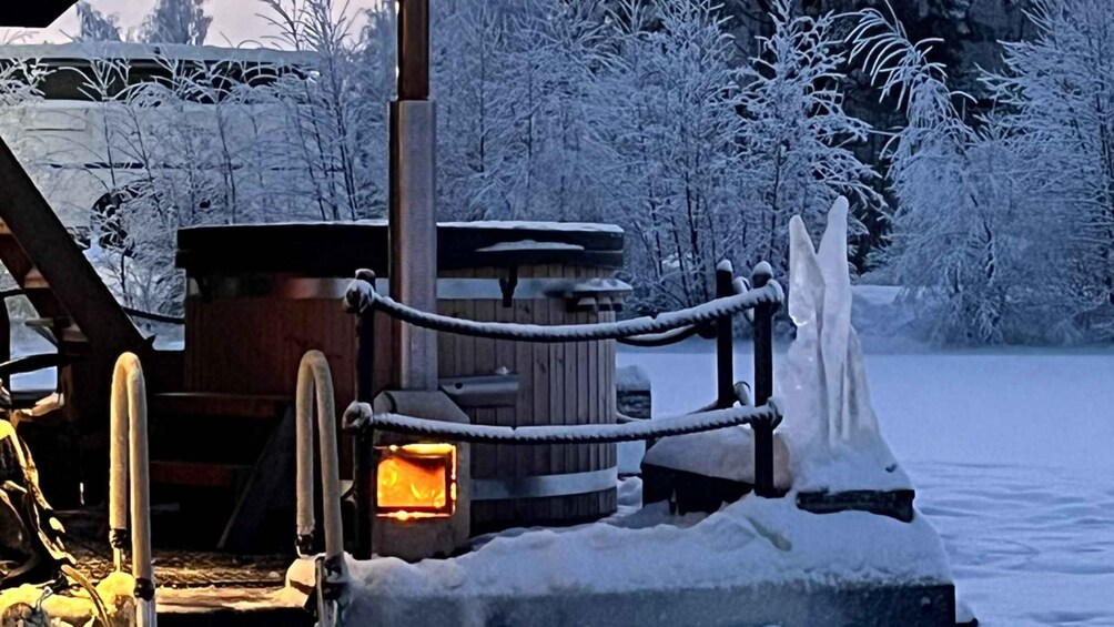 A wooden cabin with a fire burning inside, surrounded by snow-covered trees. 5