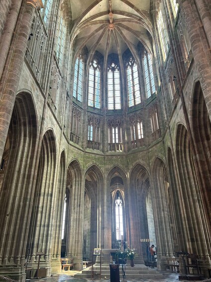 A cathedral interior with tall, arched ceilings and large stained glass windows. 5