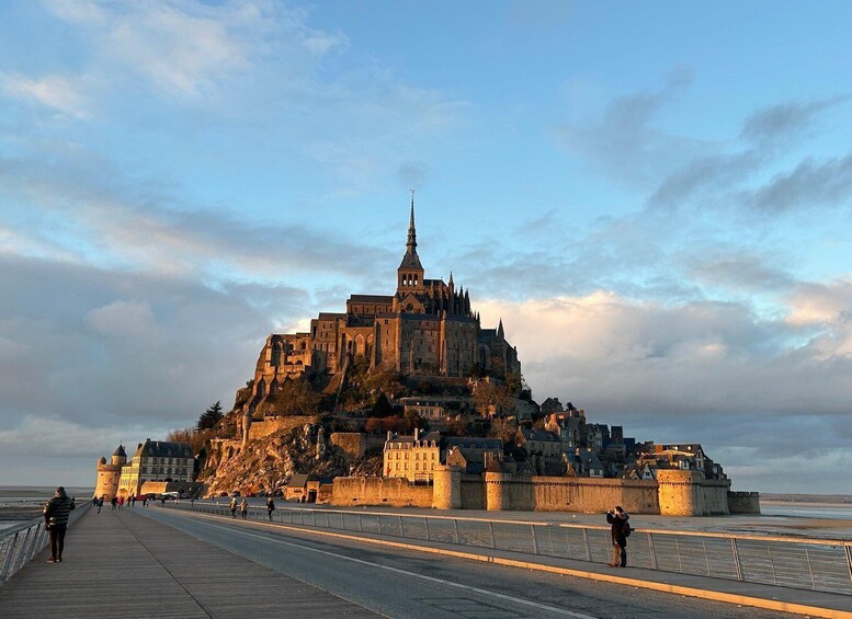 A historic castle on a hill overlooking a coastal town. 1