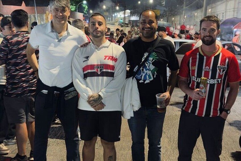 A group of people standing on a street at night. 2
