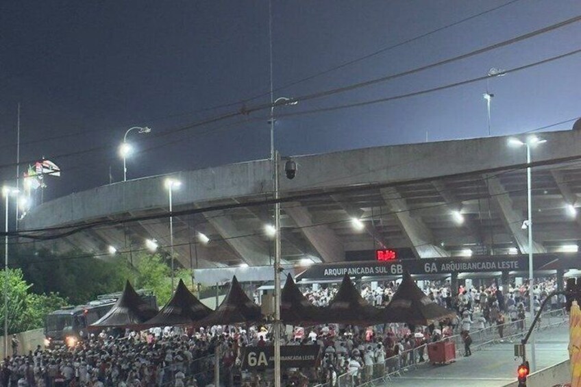 A stadium with a crowd, a covered walkway, and signage for '6A' and '6B' sections. 5